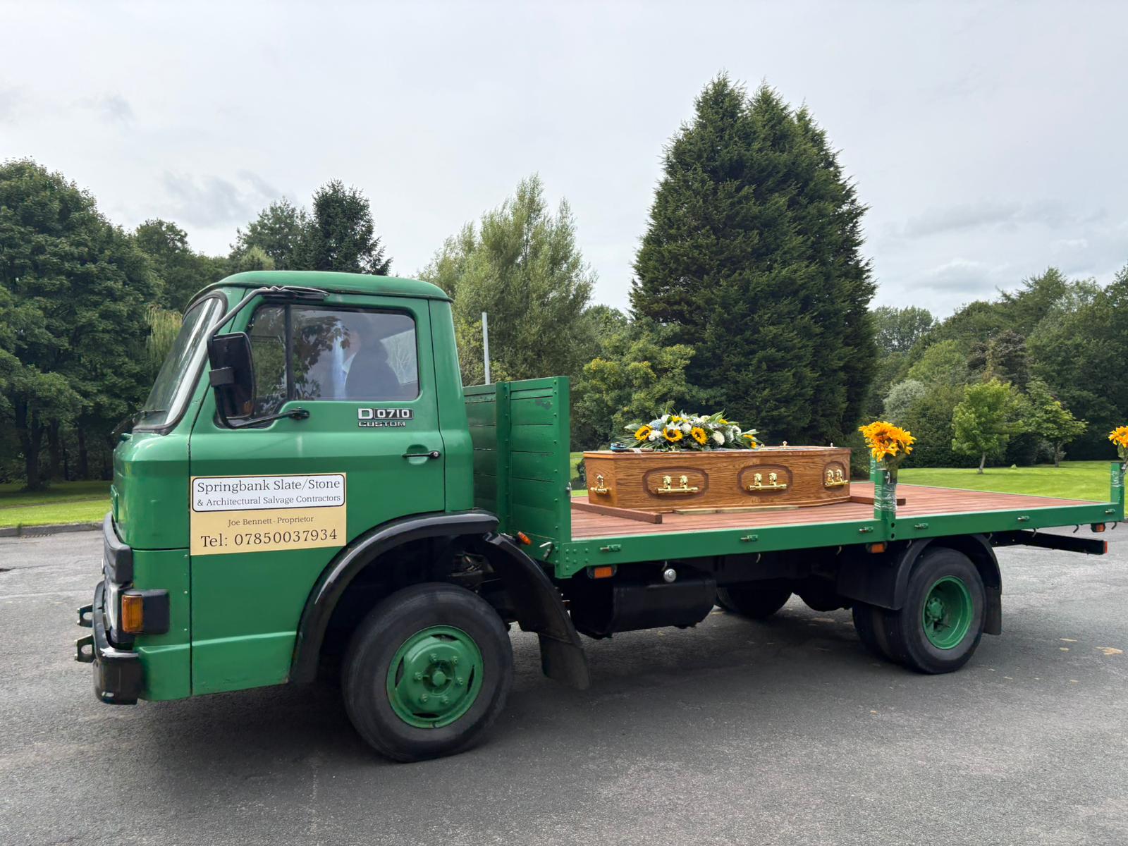 The Churnside vintage flatbed funeral carriage with oak coffin and sunflower spray